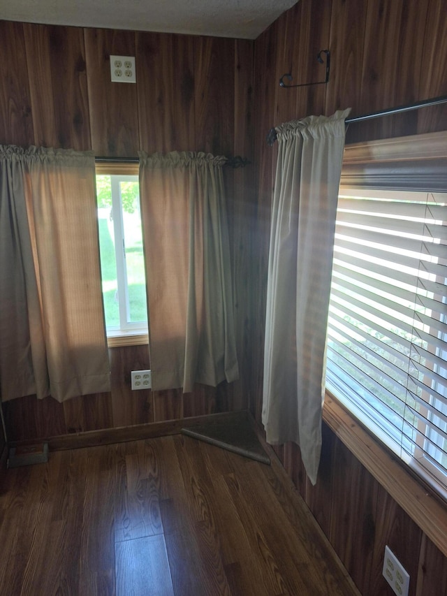 spare room with wood walls and dark hardwood / wood-style flooring