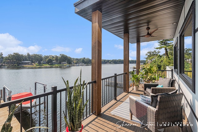 deck with a water view and a ceiling fan