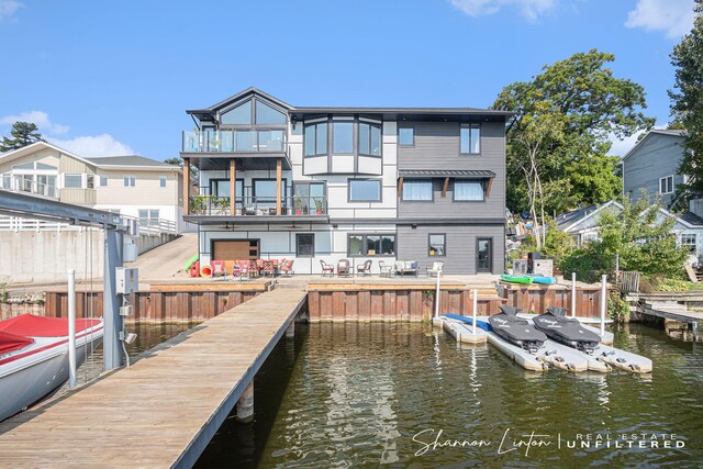 view of dock featuring a balcony and a water view