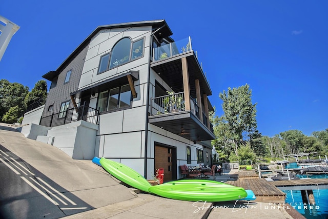view of property exterior featuring a patio, a pool, and a balcony
