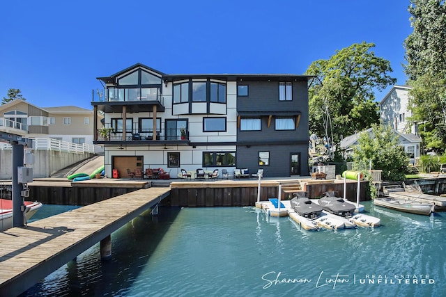 rear view of house featuring a balcony and a water view