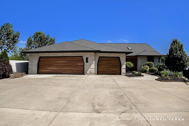 view of front of property with driveway, a garage, and brick siding