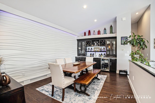 dining room with recessed lighting, dark wood finished floors, a dry bar, beverage cooler, and vaulted ceiling