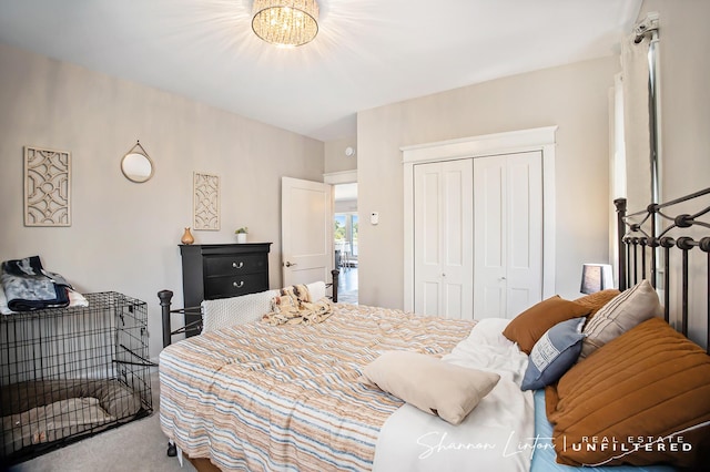 carpeted bedroom featuring a closet and a chandelier
