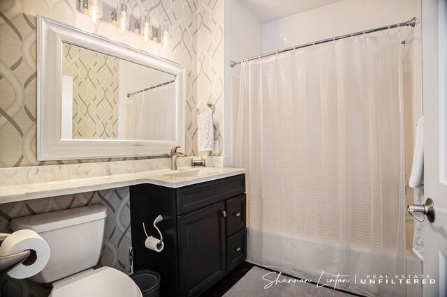 bathroom with toilet, vanity, and shower / bath combo with shower curtain