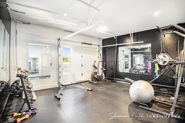 workout area featuring baseboards, a garage, and recessed lighting