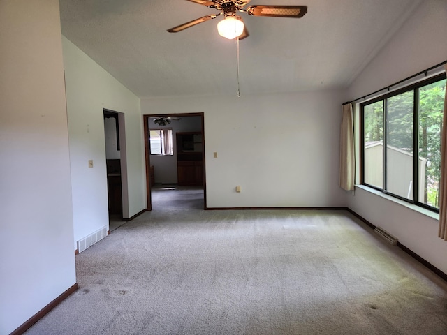 carpeted empty room with ceiling fan and vaulted ceiling