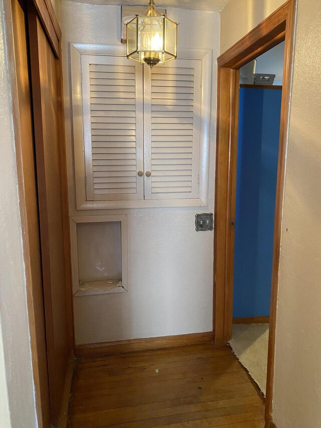 hallway featuring baseboards and hardwood / wood-style flooring