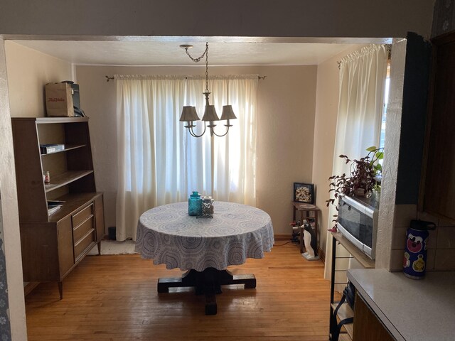 dining area with an inviting chandelier and light wood-style floors