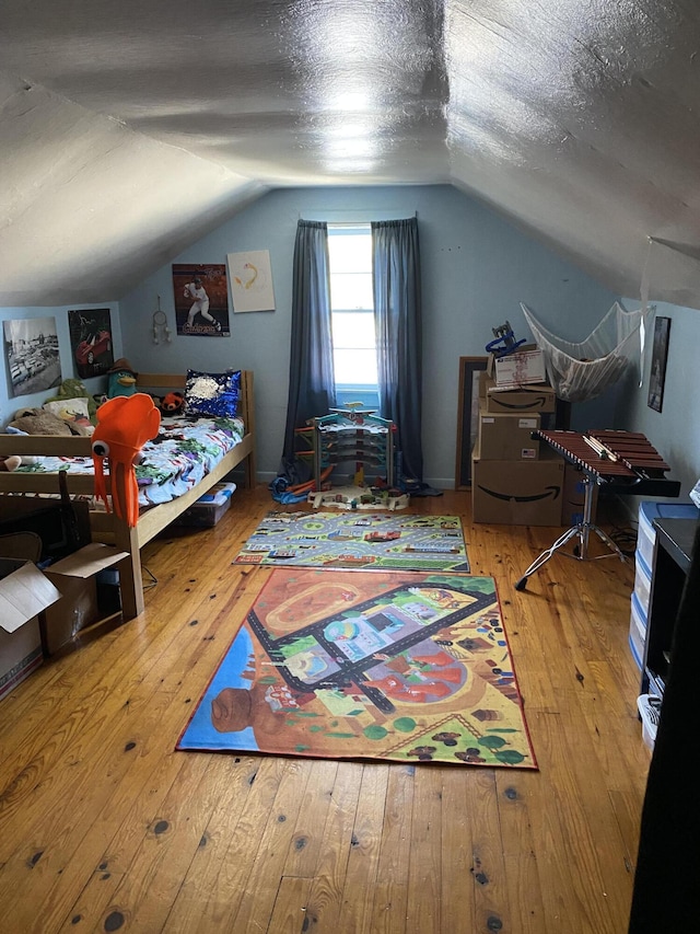bedroom featuring hardwood / wood-style flooring, lofted ceiling, and a textured ceiling