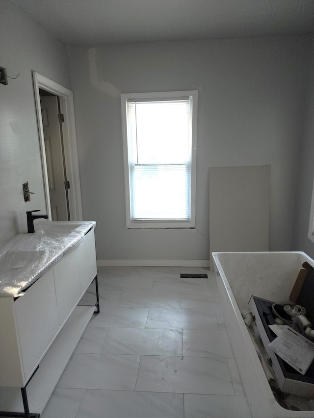 bathroom with vanity and a tub