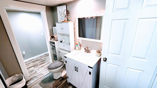 bathroom with hardwood / wood-style floors, vanity, and toilet