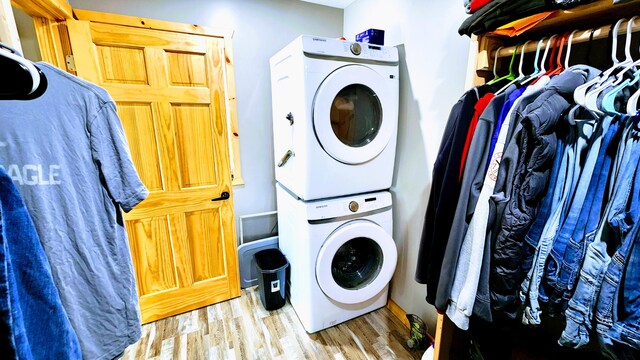 washroom with light wood-type flooring and stacked washer and dryer