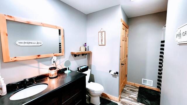 bathroom featuring hardwood / wood-style flooring, vanity, and toilet