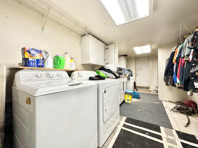 clothes washing area with washing machine and clothes dryer and cabinets