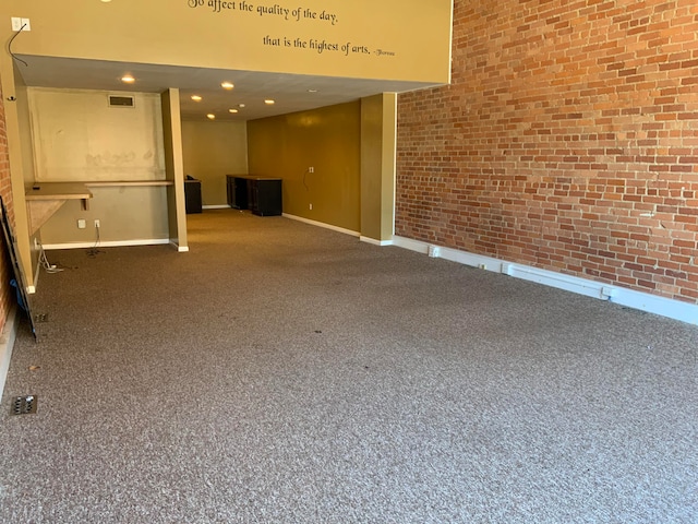 unfurnished living room with brick wall and carpet