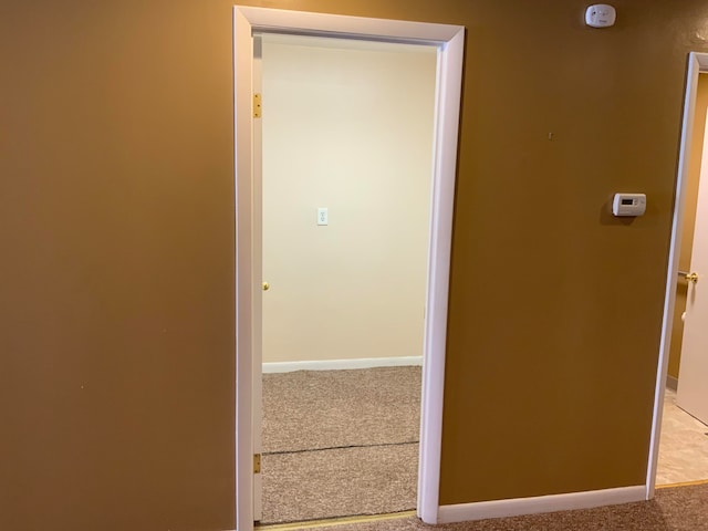 hallway featuring light colored carpet