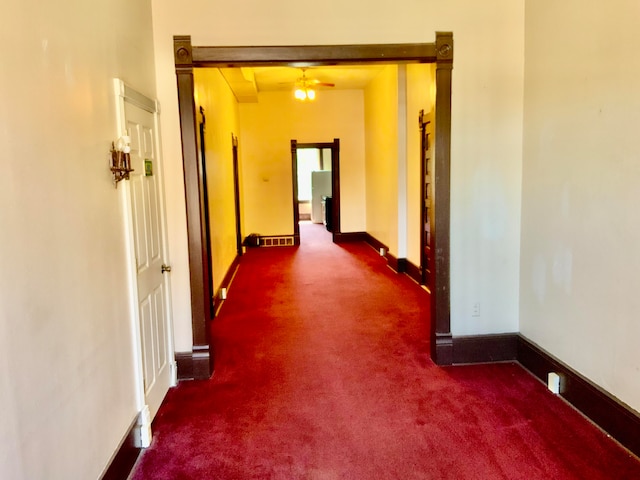 corridor featuring dark carpet