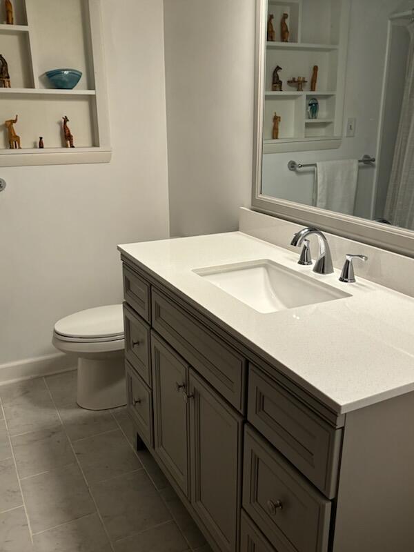 bathroom featuring tile patterned floors, vanity, and toilet