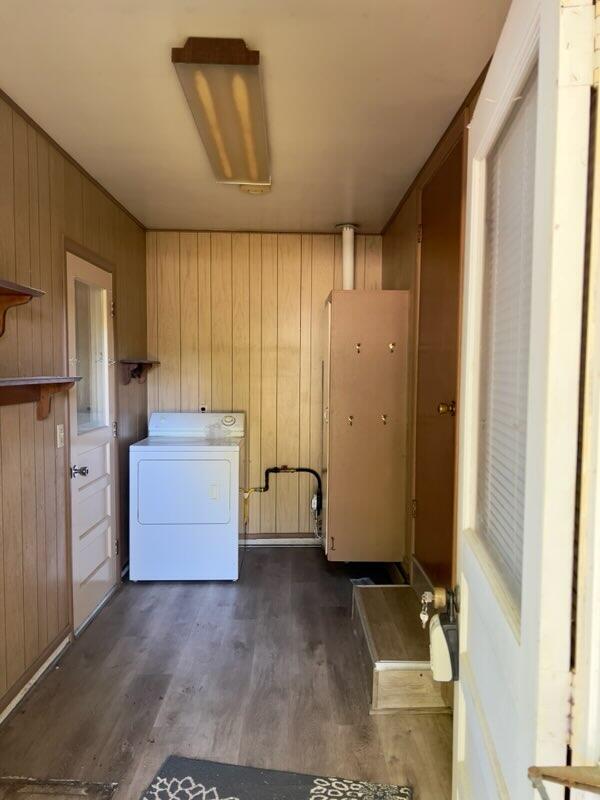 laundry area with washer / dryer, wooden walls, and dark hardwood / wood-style flooring