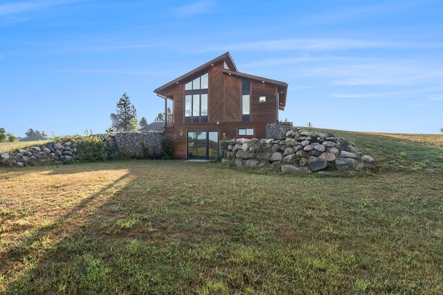 rear view of property featuring a lawn