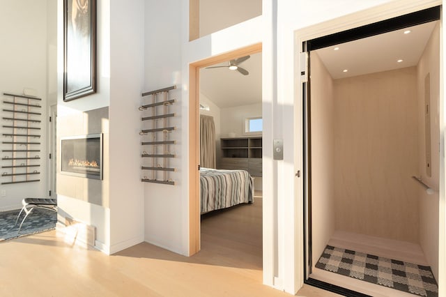 bathroom with ceiling fan, hardwood / wood-style flooring, and elevator