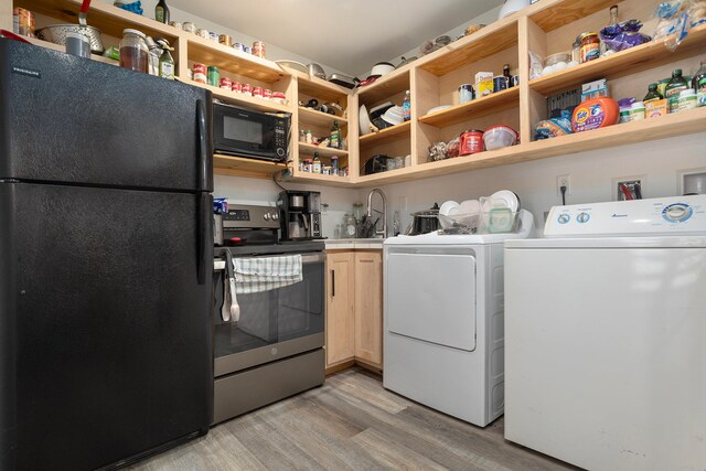 laundry area with washer and clothes dryer and light hardwood / wood-style floors