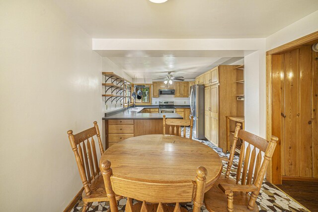 dining room with ceiling fan, sink, and dark hardwood / wood-style flooring