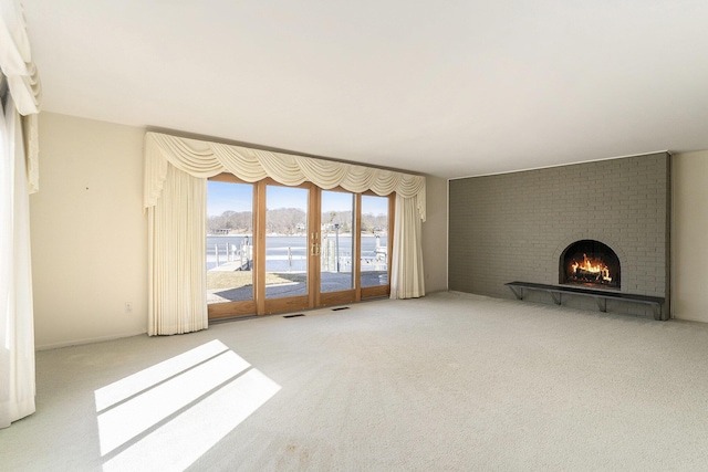unfurnished living room with visible vents, a fireplace, and carpet floors