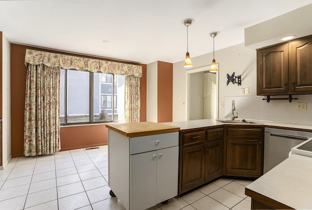 kitchen with dishwasher, light countertops, light tile patterned floors, a peninsula, and a sink
