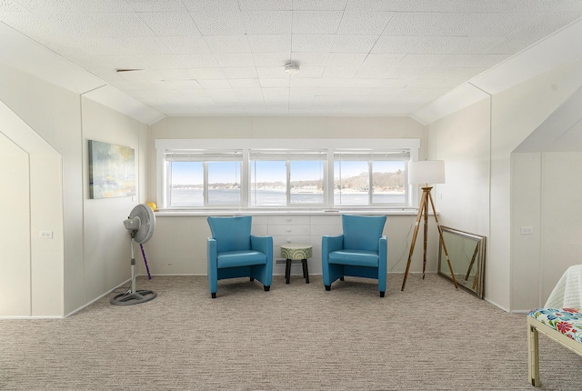 sitting room featuring carpet flooring, a healthy amount of sunlight, and lofted ceiling