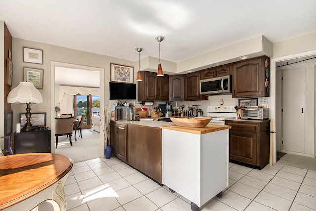 kitchen with a sink, stainless steel microwave, white electric stove, dark brown cabinetry, and light tile patterned floors