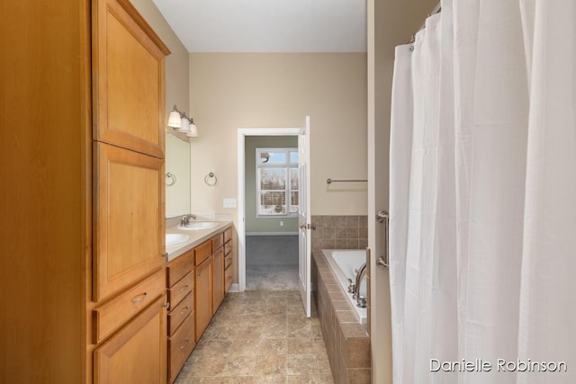 bathroom with vanity and tiled tub