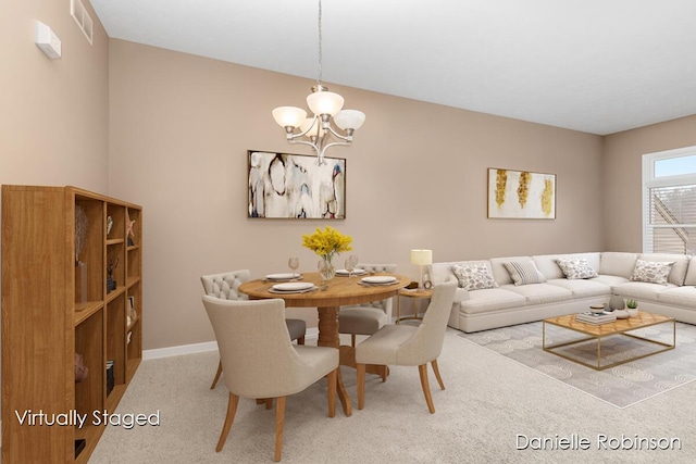 carpeted dining room featuring an inviting chandelier