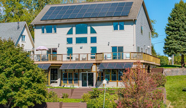 back of property with a balcony and solar panels