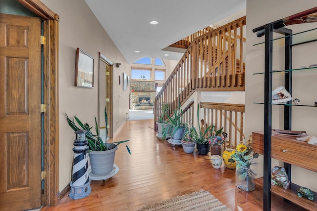 foyer entrance featuring recessed lighting, stairway, baseboards, and wood finished floors