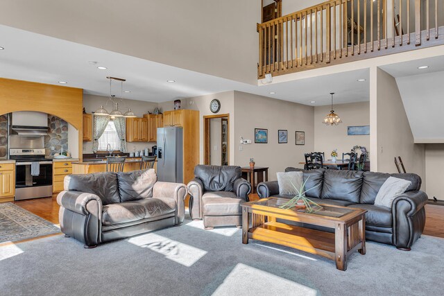 living room with light wood-type flooring and a towering ceiling