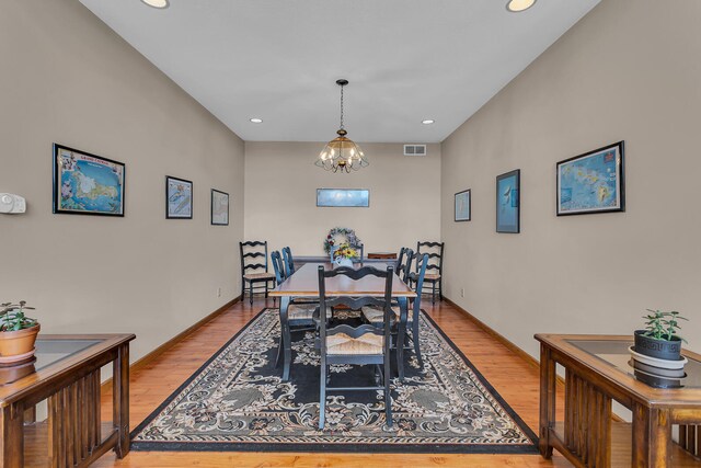 dining room with light wood-type flooring and a chandelier