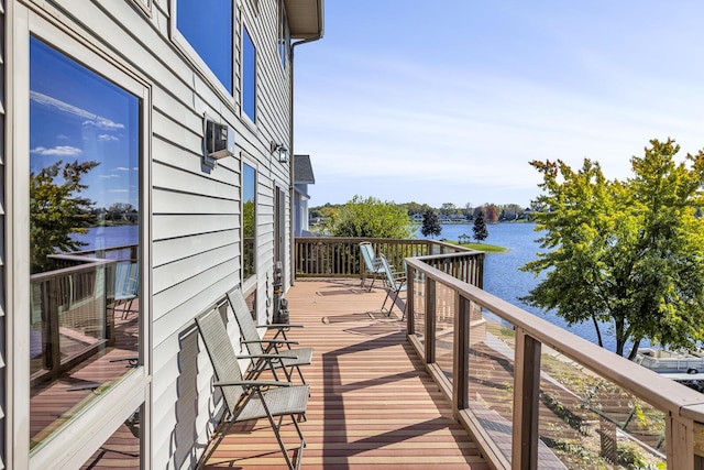 wooden terrace featuring an AC wall unit and a water view