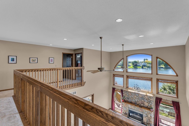 hall featuring baseboards, recessed lighting, a water view, and light colored carpet