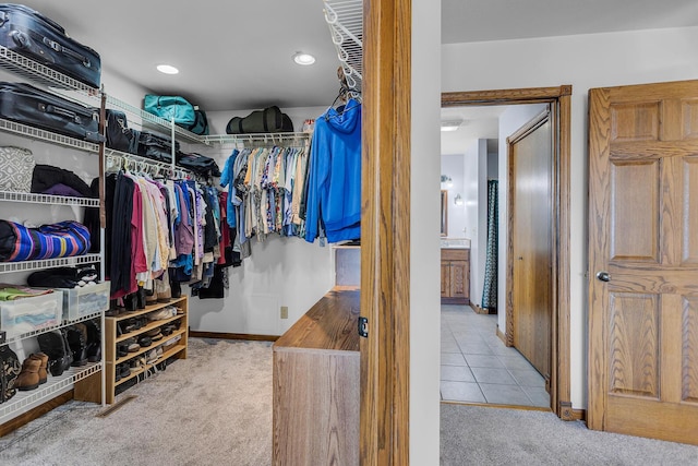 spacious closet featuring tile patterned floors and carpet