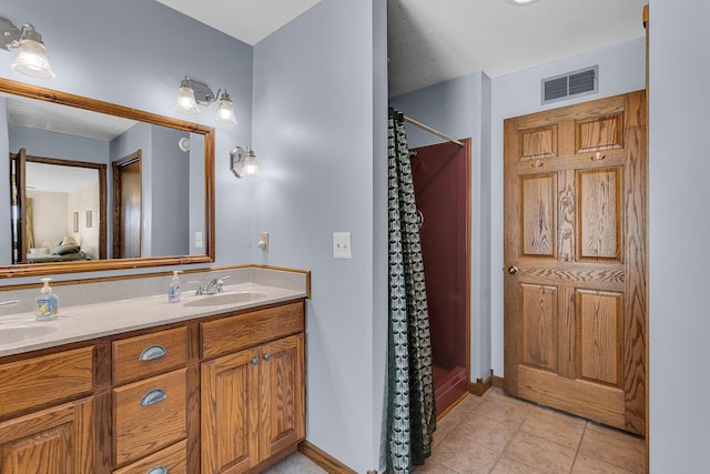 full bath with a sink, baseboards, visible vents, tile patterned flooring, and a shower with shower curtain