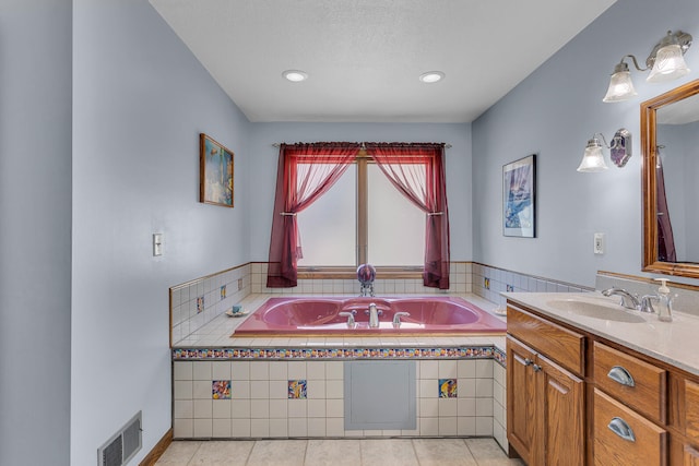 bathroom with vanity, tiled bath, tile patterned flooring, and a textured ceiling