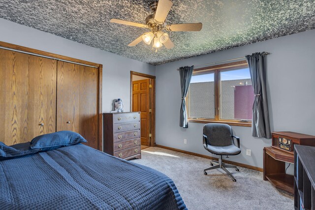 bedroom featuring light carpet, ceiling fan, and a closet