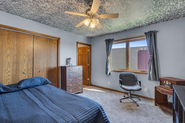 carpeted bedroom featuring baseboards, a closet, and ceiling fan