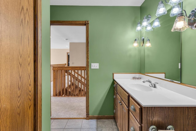 bathroom featuring tile patterned floors, vanity, a notable chandelier, and baseboards