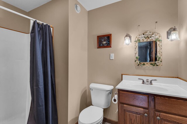 bathroom featuring curtained shower, vanity, and toilet