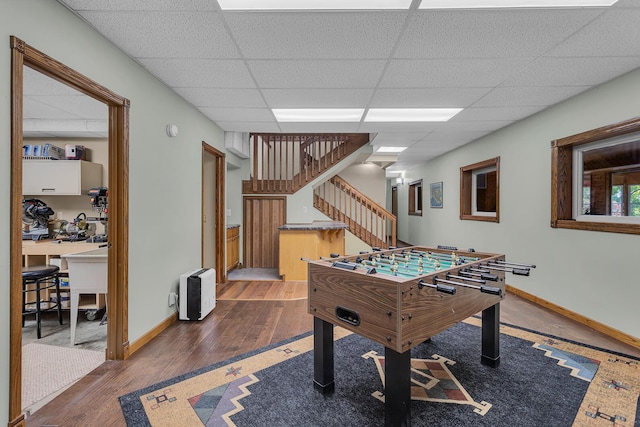 game room featuring wood finished floors, baseboards, and a drop ceiling