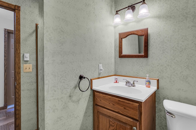 bathroom with vanity, toilet, and parquet floors