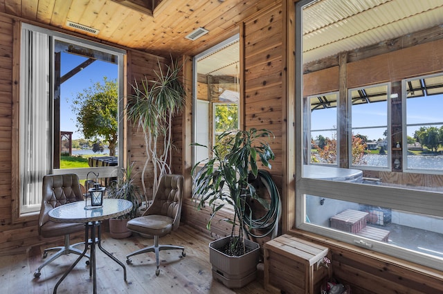 interior space featuring wood-type flooring, wooden walls, and plenty of natural light